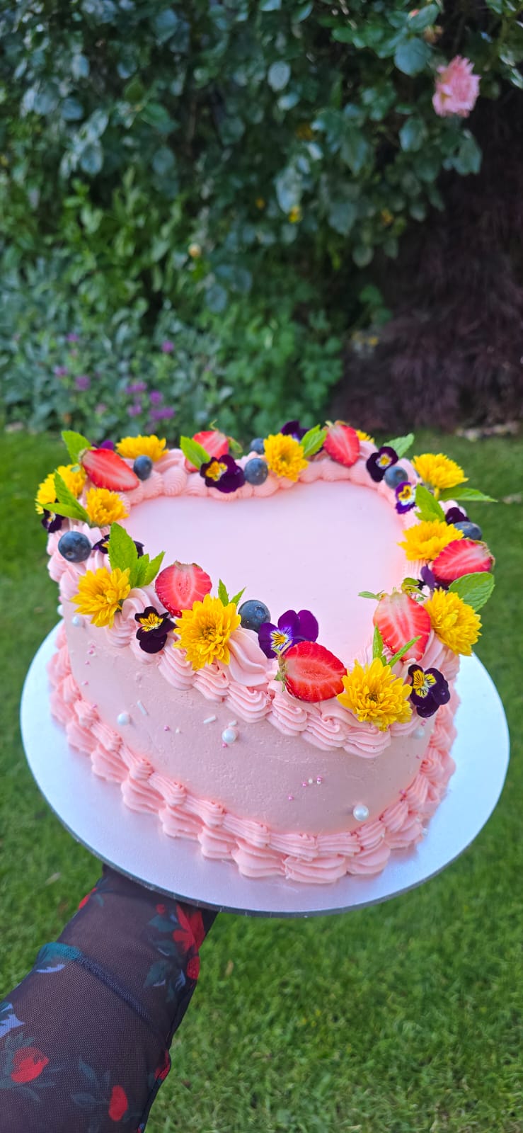 Torta corazón rosa con flores y berries