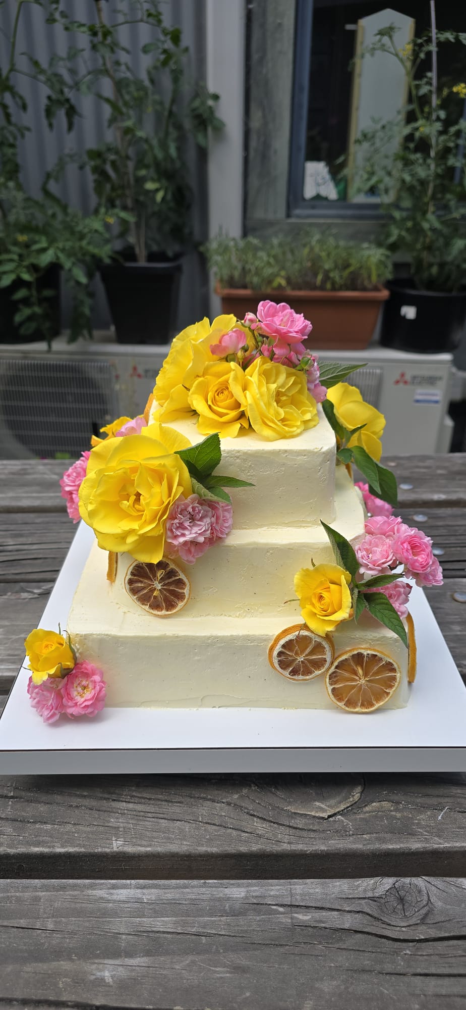 Torta de tres pisos con rosas amarillas y rosadas